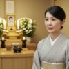 弔電への口頭でのお礼を伝える喪服姿の日本人女性。静かな室内で丁寧に感謝を述べているシーン。